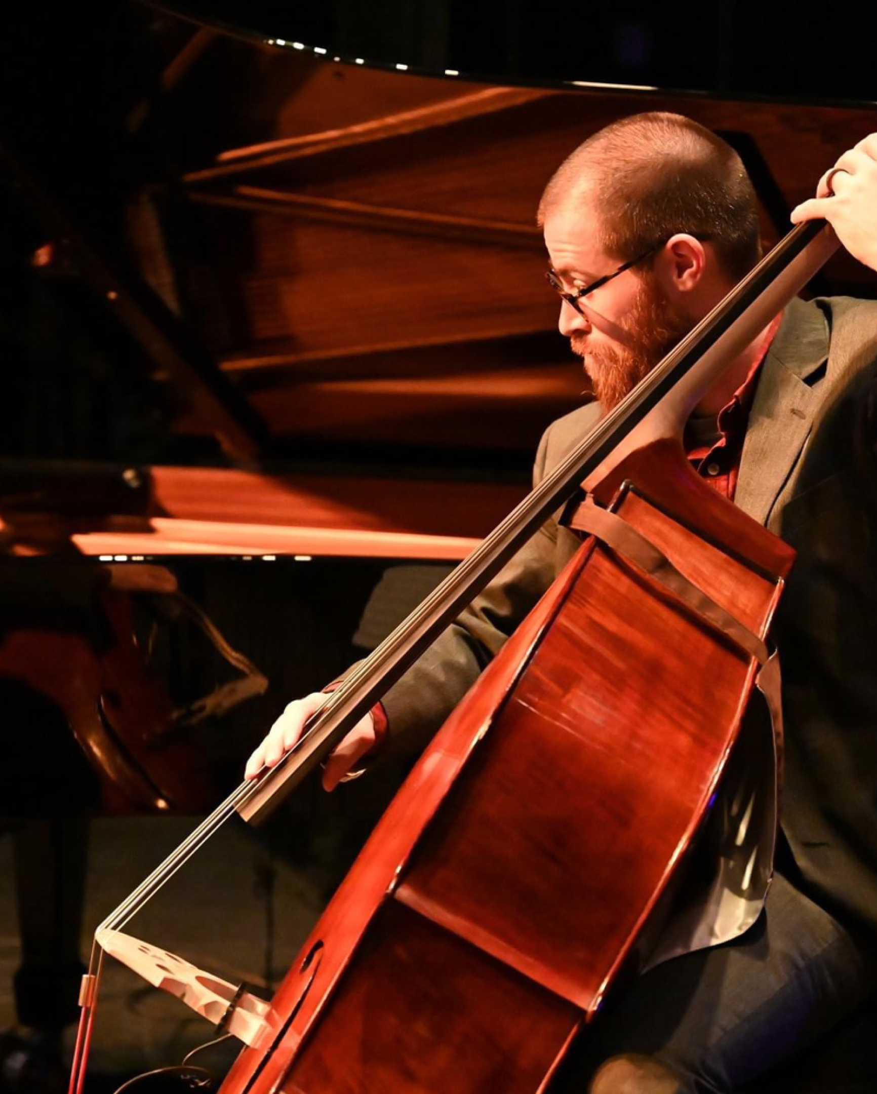 Person plays a bass in a symphony.