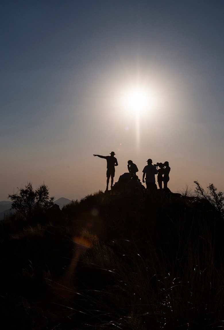 Hikers at sunrise deciding where to go.