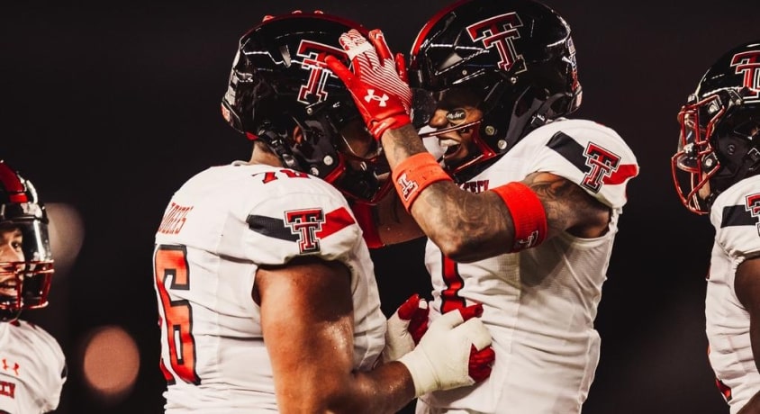 Texas Tech football players hug each other.