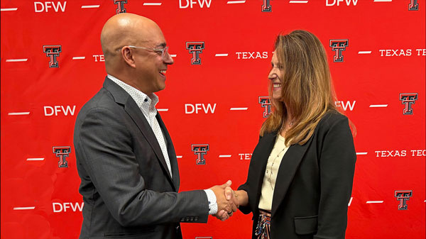 Two people shake hands in front of a red Texas Tech DFW backdrop.