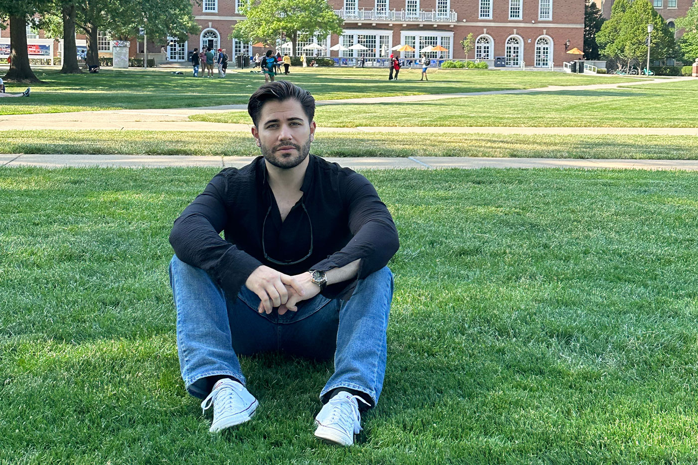 Devi sits on the lawn in front of the Quad Building at the University of Illinois during his summer fellowship.