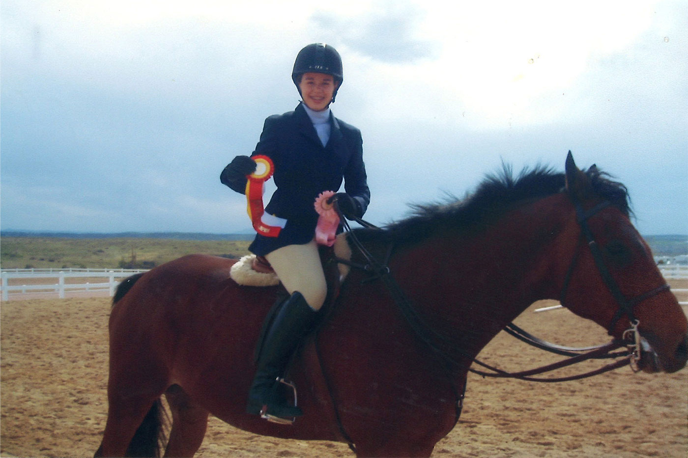 Megan Sprague on a horse and holding ribbons
