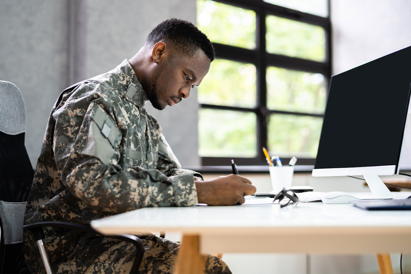 Soldier writing at desk. 