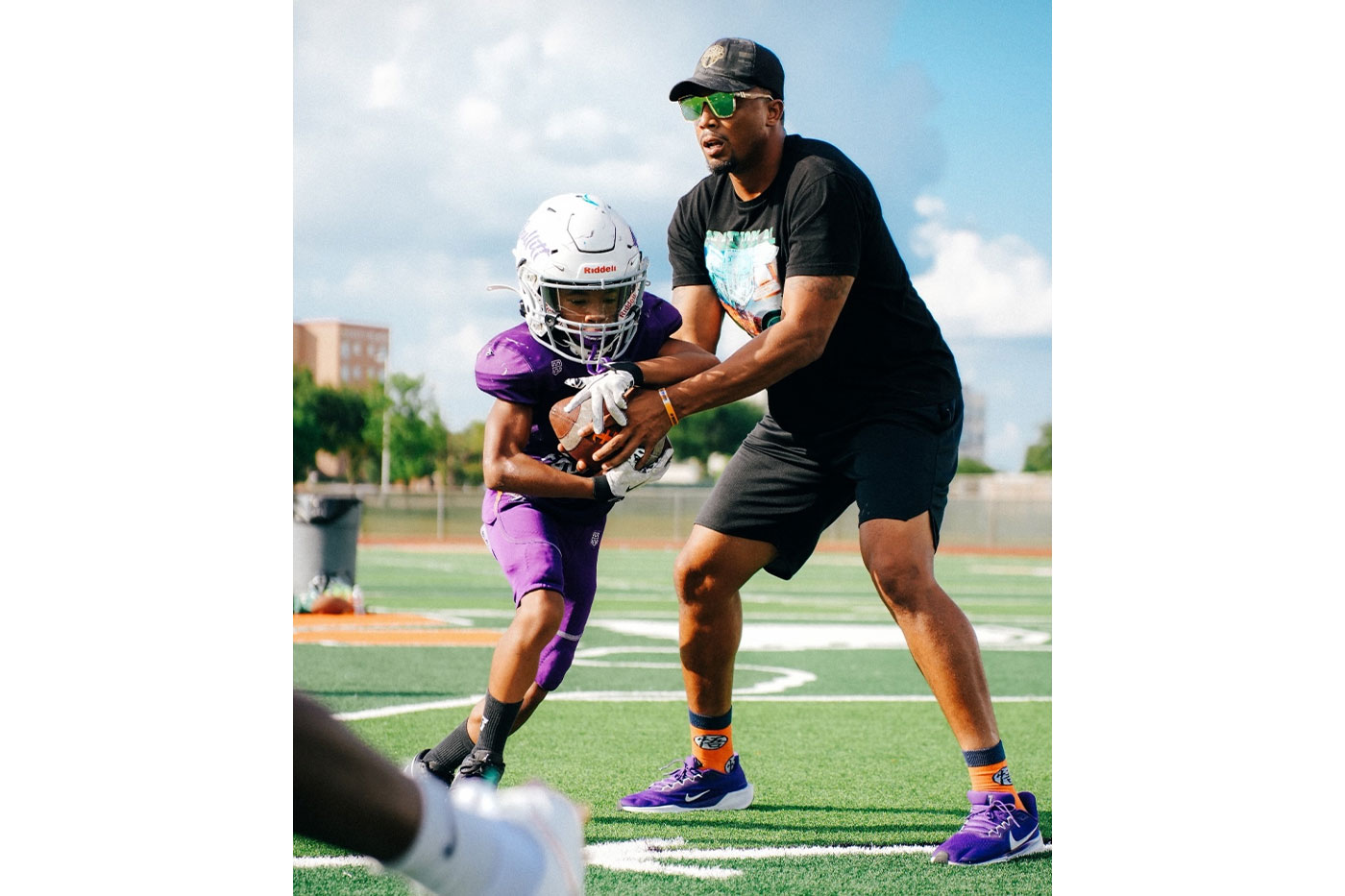 Terrance handing football off to youngster.