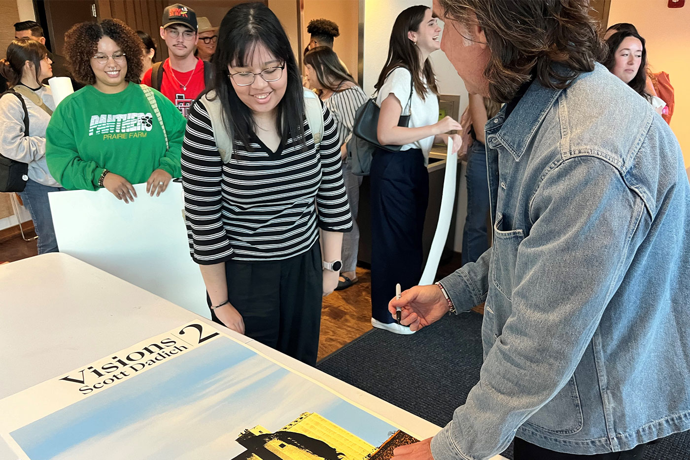 Dadich signing a poster for Alessandra Rios