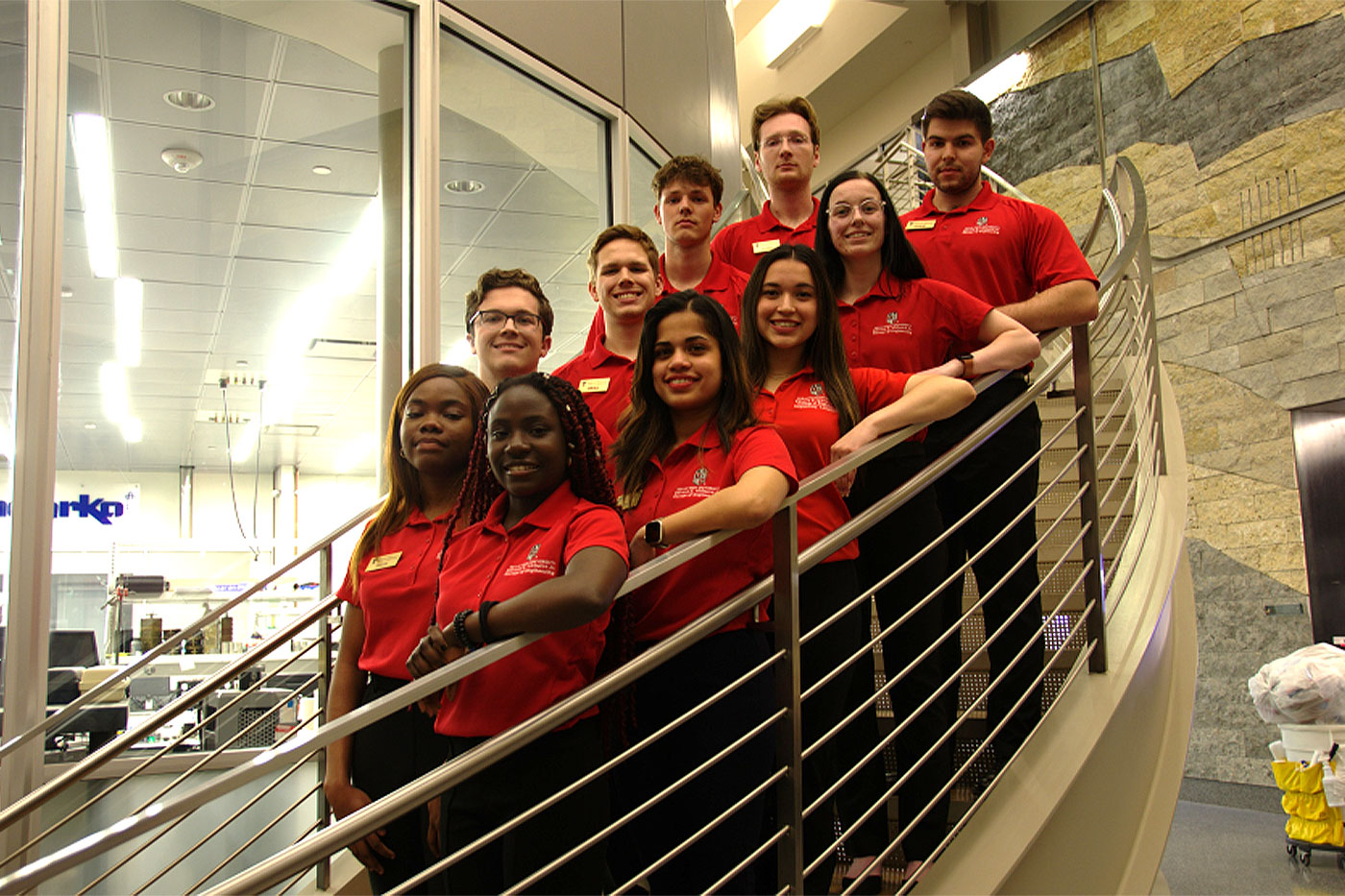 Shruti with other students lined up on a staircase