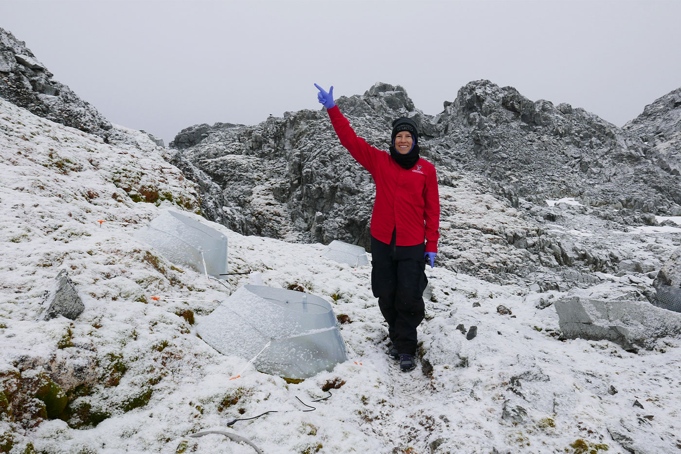 Natasja van Gestel  giving a "Guns Up" while standing on a glacier. 