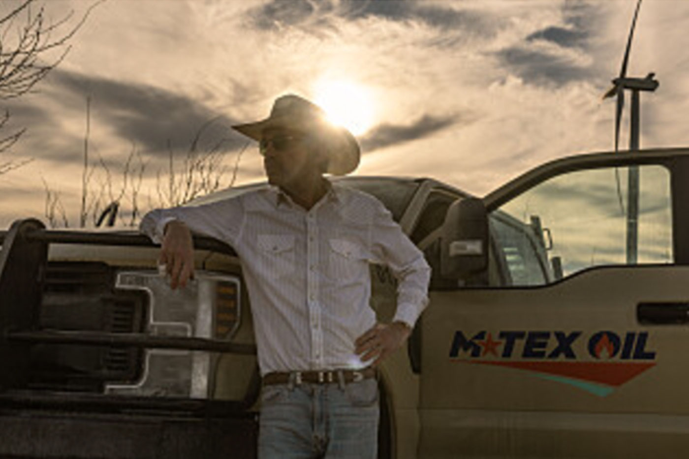 Billy Bob Thornton in front of truck and wind turbine. 